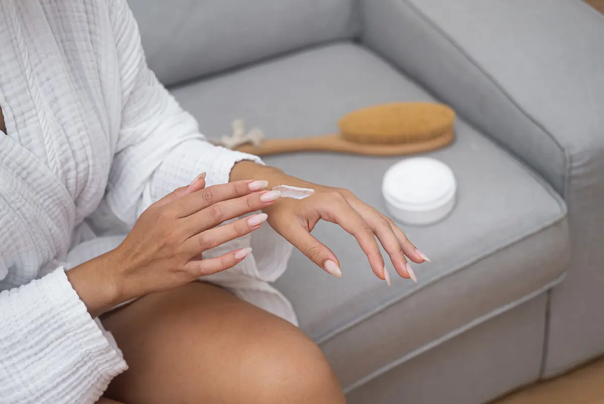 Woman moisturizing skin with lotion