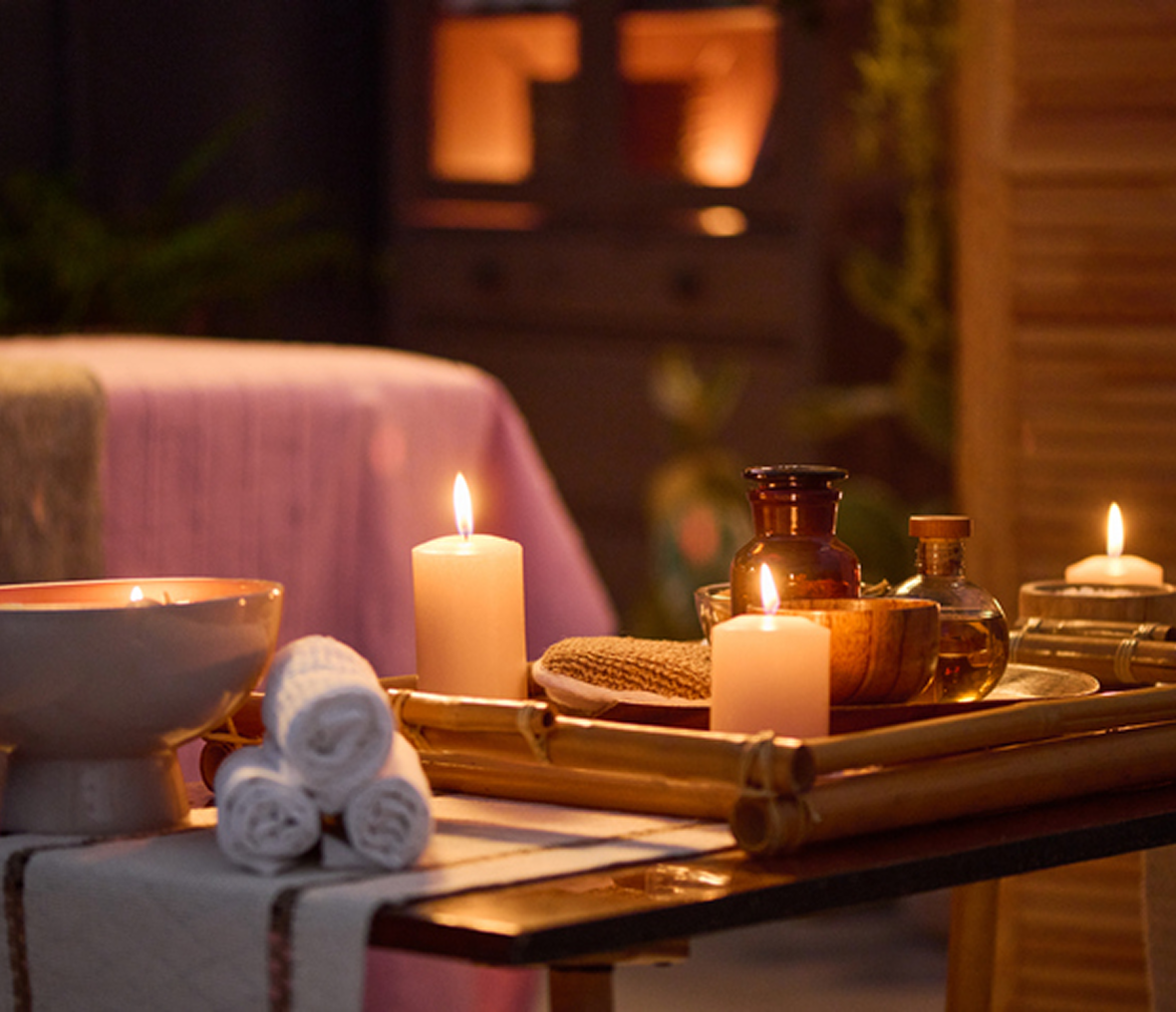 Spa candles and towels on wooden tray